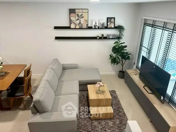 Modern living room with stylish decor, cozy gray sofa, and sleek entertainment unit.