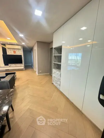 Modern living room with sleek design, featuring built-in cabinets and stylish flooring.