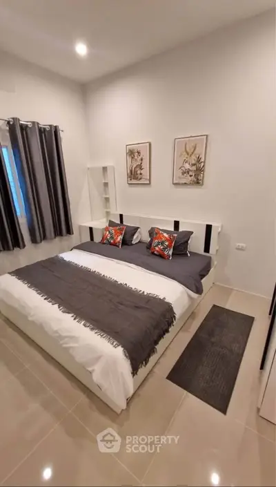 Modern bedroom with stylish decor and cozy ambiance, featuring a comfortable bed and elegant furnishings.