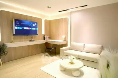 Modern living room with sleek design, wall-mounted TV, and cozy seating area.