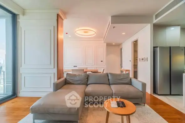Spacious modern living room with elegant decor and open layout, featuring a cozy sofa and stylish lighting.