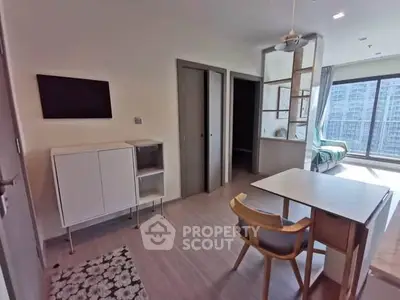 Modern studio apartment with open layout and large windows offering city views.