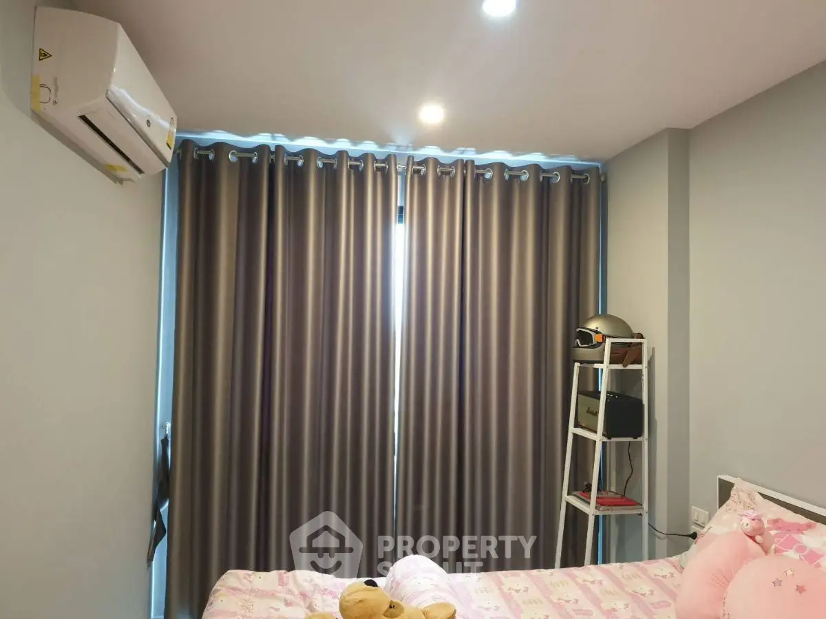 Cozy bedroom with air conditioning and stylish curtains, perfect for relaxation.