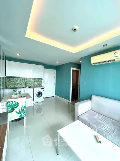 Modern living room with sleek design, featuring a washing machine and stylish kitchen area.