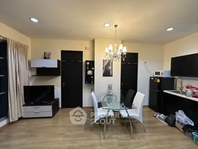 Modern living room with dining area and sleek kitchen in open layout apartment.