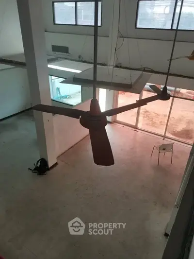 Spacious industrial-style interior with high ceilings and large windows