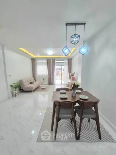 Modern living room with elegant dining area and stylish lighting in a bright open space.