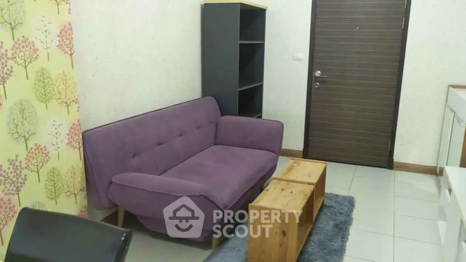 Cozy living room with purple sofa and wooden coffee table, ideal for relaxation.