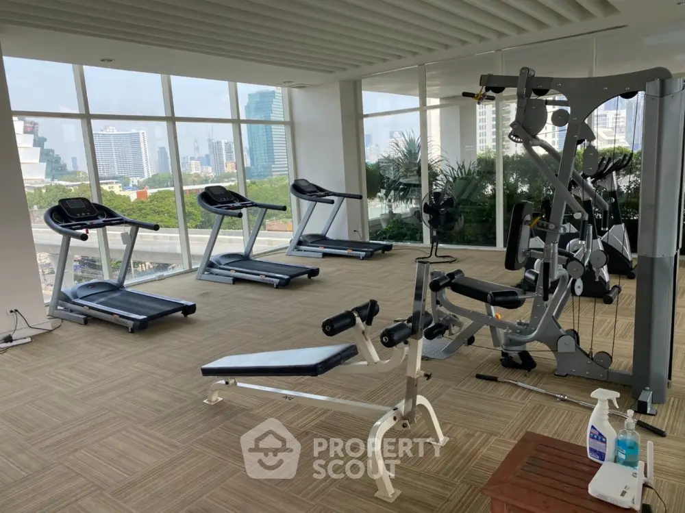 Spacious gym with modern equipment and panoramic city views
