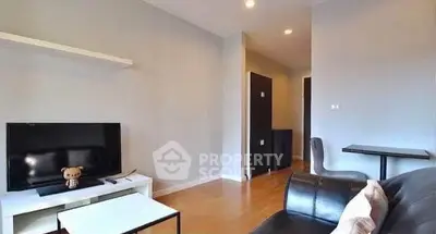 Modern living room with sleek furniture and TV setup, perfect for relaxation.
