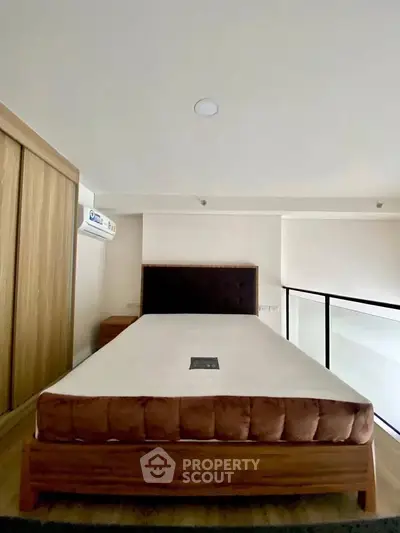Modern bedroom with minimalist design and wooden accents, featuring a comfortable bed and built-in wardrobe.