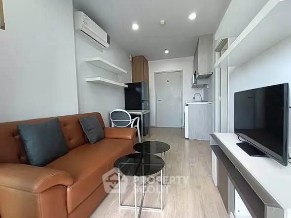Modern living room with sleek furniture and open kitchen layout in a stylish apartment.