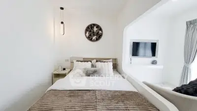 Modern bedroom with cozy decor and wall-mounted TV in a bright, minimalist design.