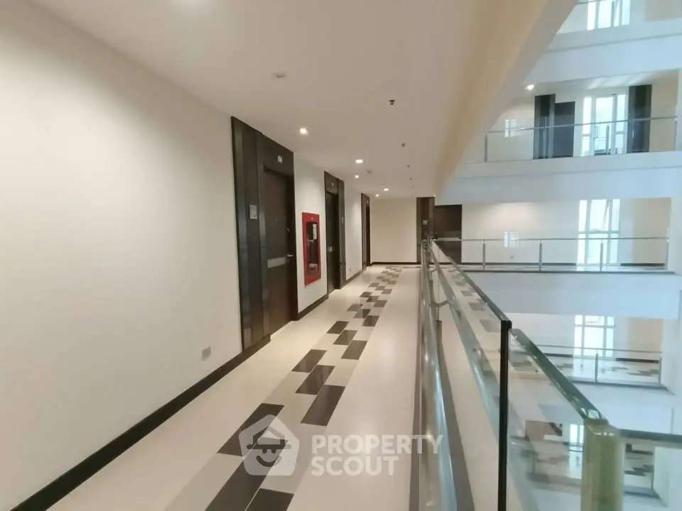Modern apartment building corridor with sleek design and glass railings