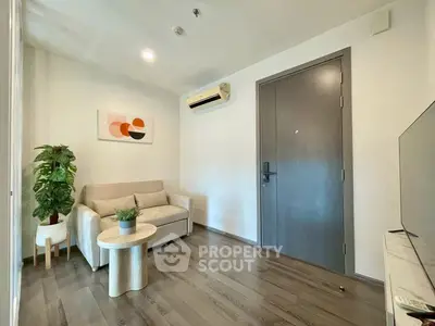 Modern living room with sleek design, featuring a cozy sofa, stylish decor, and air conditioning.