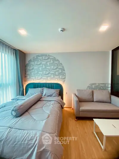 Modern bedroom with stylish decor, featuring a cozy bed and elegant sofa, perfect for relaxation.