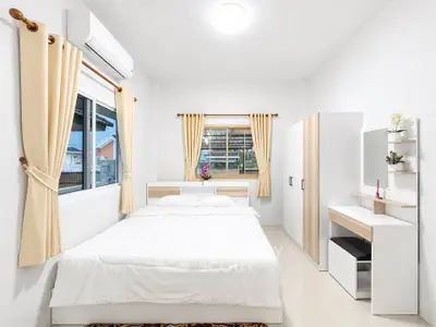 Bright and cozy bedroom with modern furnishings and large windows for natural light.