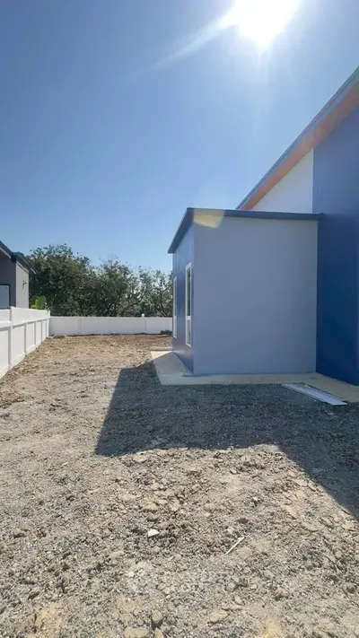 Modern exterior view of a newly constructed home with clear blue sky.