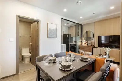 Modern open-plan living and dining area with stylish decor and integrated kitchen appliances.