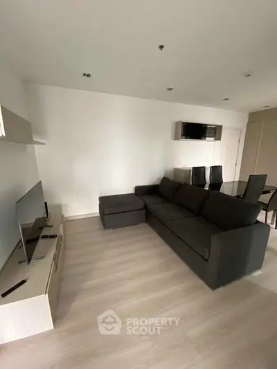 Modern living room with sleek furniture and TV setup, perfect for relaxation.