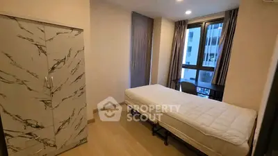 Cozy bedroom with modern wardrobe and large window in a stylish apartment.