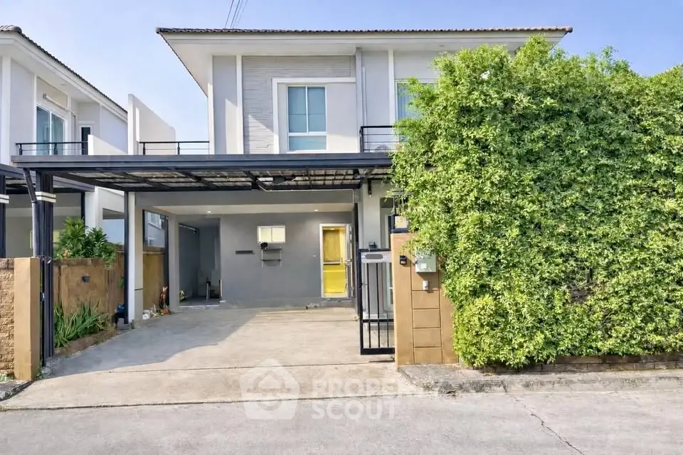 Modern two-story house with lush greenery and spacious driveway