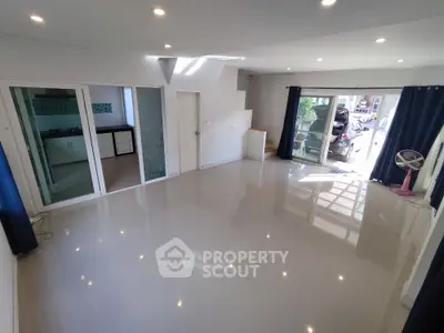 Spacious modern living room with large windows and glossy tile flooring