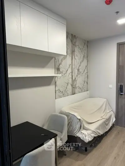 Modern small bedroom with sleek furniture and marble accent wall