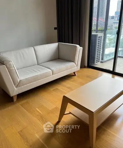 Modern living room with stylish sofa and wooden coffee table, featuring large windows with city view.