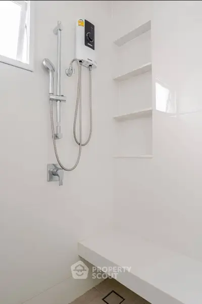 Modern bathroom with sleek shower and built-in shelves, perfect for minimalist design enthusiasts.