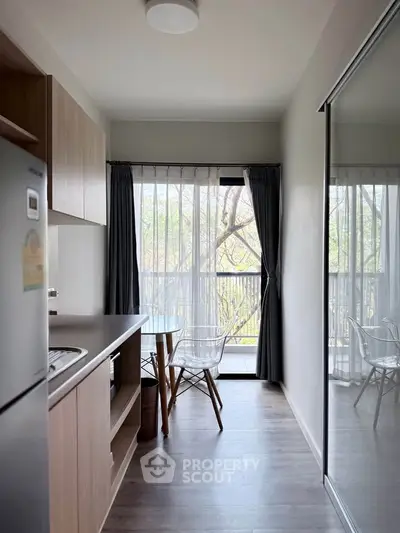 Modern kitchen with open layout and natural light, featuring sleek appliances and a cozy dining area.