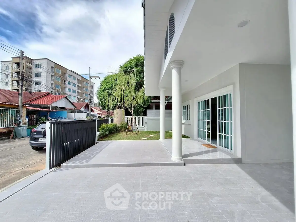 Spacious modern home exterior with large driveway and elegant columns