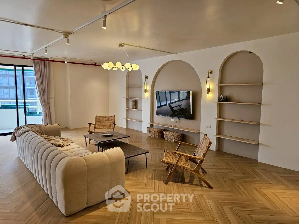 Spacious modern living room with elegant decor and large windows offering natural light.