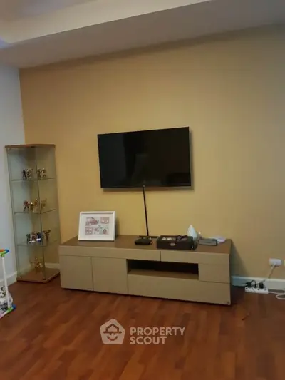 Modern living room with sleek TV setup and wooden flooring, perfect for cozy family gatherings.