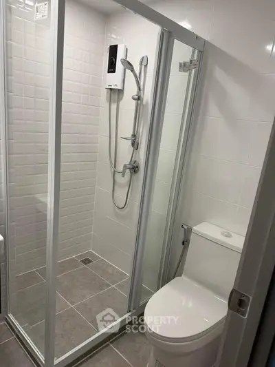 Modern bathroom with glass shower enclosure and sleek fixtures in a contemporary apartment.