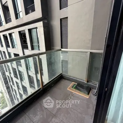 Modern urban balcony with glass railing and city view, perfect for relaxation.
