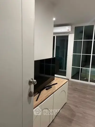 Modern living room with sleek TV stand and large window for natural light.