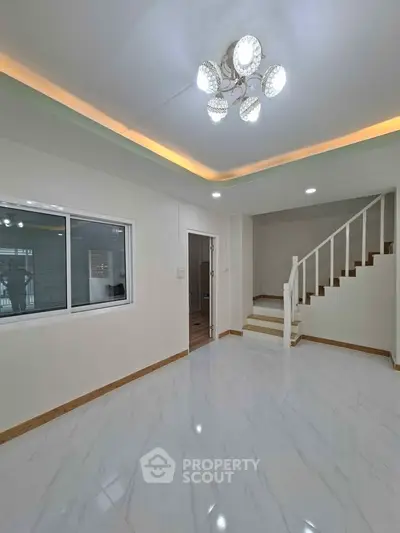 Spacious modern living room with elegant staircase and stylish lighting