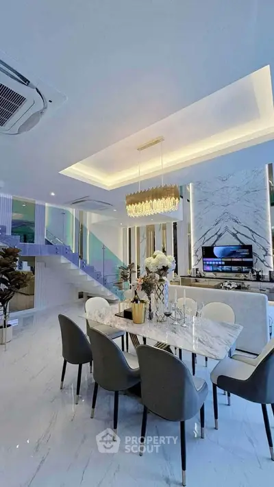 Luxurious open-plan living and dining area with modern decor and elegant lighting.