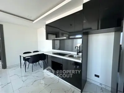 Modern kitchen with sleek black cabinetry and dining area, featuring marble flooring.