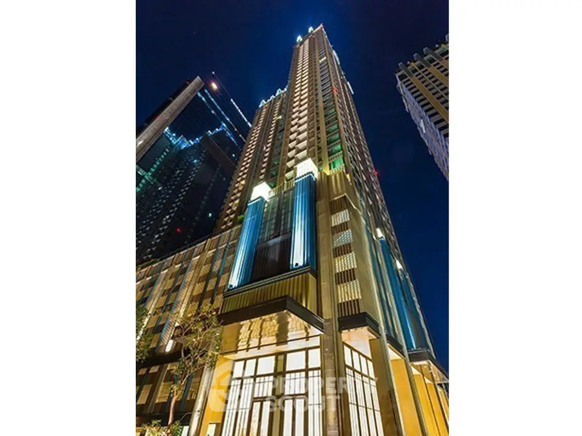 Stunning night view of a modern high-rise building with illuminated facade in a vibrant cityscape.