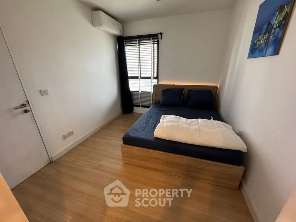 Cozy bedroom with modern decor and natural light, featuring a comfortable bed and stylish wooden flooring.