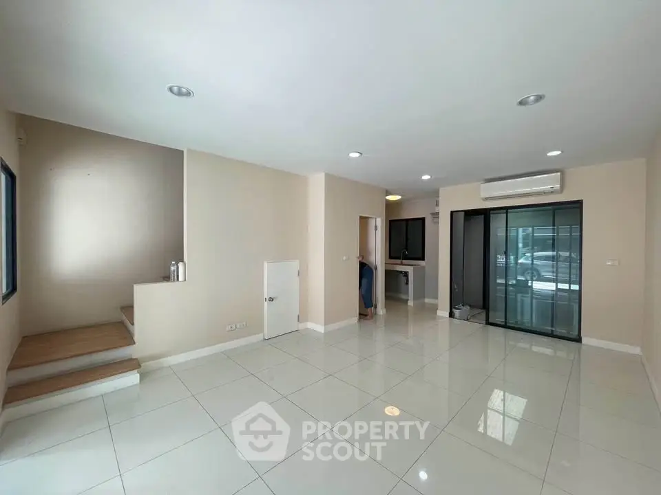 Spacious modern living room with sleek tile flooring and natural light
