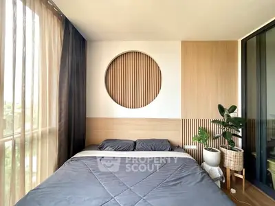 Modern bedroom with stylish decor and large window offering natural light