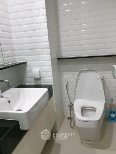 Modern bathroom with sleek white fixtures and black countertop