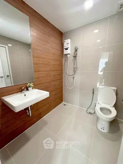 Modern bathroom with sleek fixtures and wood accent wall
