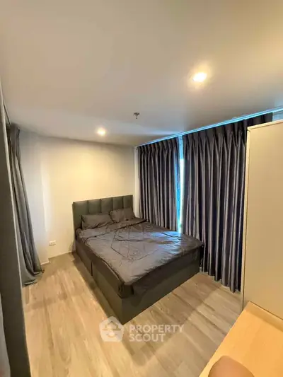 Modern bedroom with stylish curtains and cozy bed in a contemporary apartment.