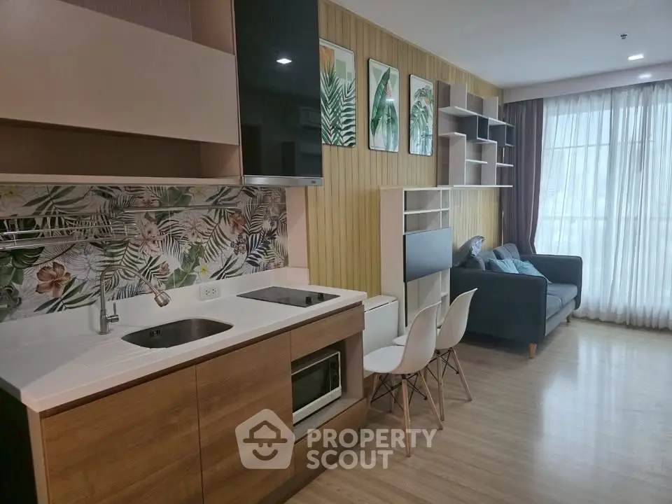 Modern open-layout kitchen and living room with stylish decor and natural light.