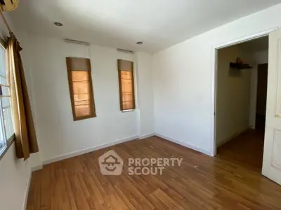 Spacious empty room with wooden flooring and natural light