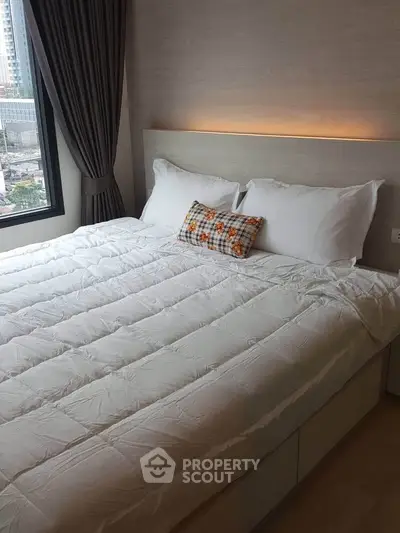 Cozy bedroom with modern design and city view, featuring a comfortable bed and stylish decor.